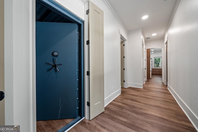 corridor featuring recessed lighting, baseboards, crown molding, and wood finished floors