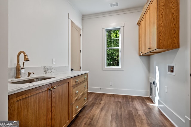 clothes washing area with washer hookup, a sink, visible vents, baseboards, and cabinet space