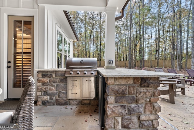 view of patio / terrace featuring a bar, a grill, and exterior kitchen