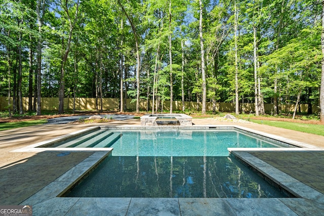 view of pool featuring a pool with connected hot tub and a fenced backyard