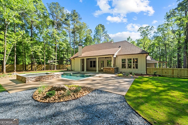 back of property featuring a fenced in pool, a chimney, board and batten siding, an in ground hot tub, and a fenced backyard