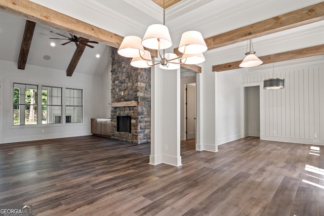 unfurnished living room with baseboards, dark wood finished floors, vaulted ceiling with beams, a fireplace, and ceiling fan with notable chandelier