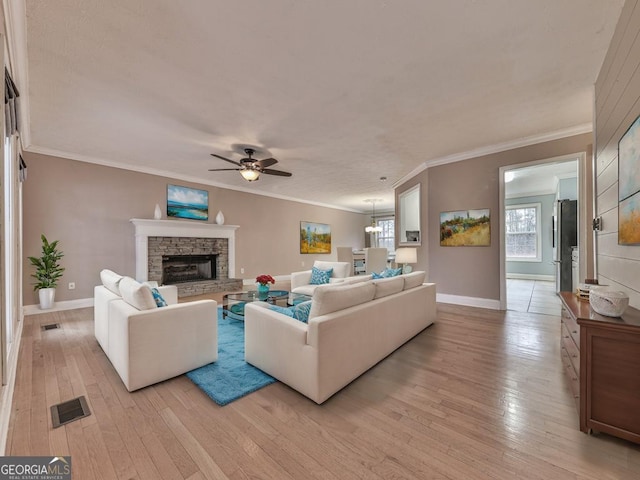 living room featuring crown molding, a healthy amount of sunlight, and light wood-type flooring