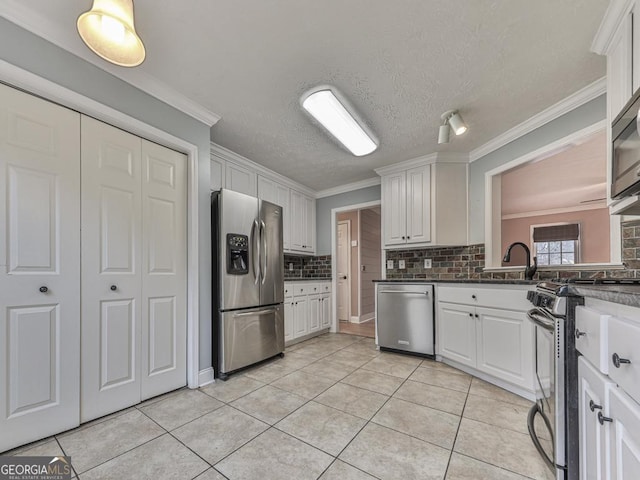 kitchen with light tile patterned flooring, white cabinetry, a textured ceiling, appliances with stainless steel finishes, and backsplash