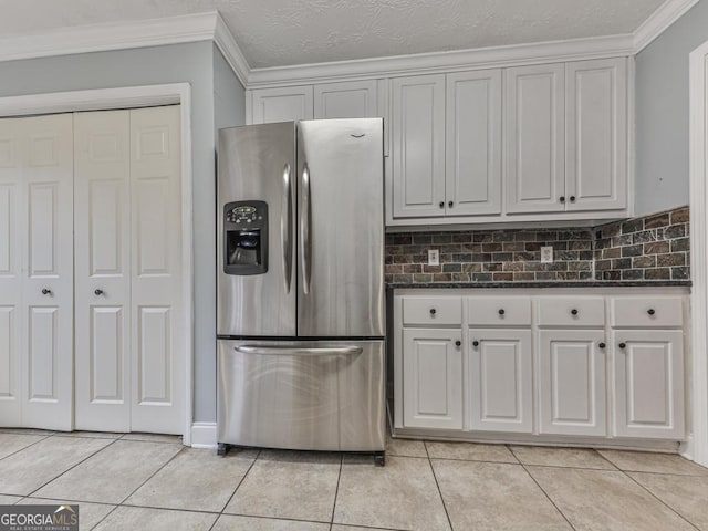 kitchen with white cabinetry, stainless steel refrigerator with ice dispenser, ornamental molding, and light tile patterned flooring