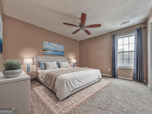 bedroom featuring dark carpet, a textured ceiling, and ceiling fan