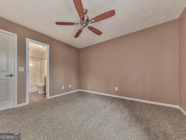 unfurnished bedroom featuring ensuite bathroom, carpet flooring, a textured ceiling, and ceiling fan