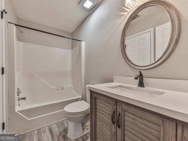 full bathroom featuring washtub / shower combination, wood-type flooring, toilet, and vanity