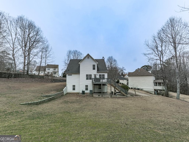 rear view of property with a wooden deck, central air condition unit, and a lawn