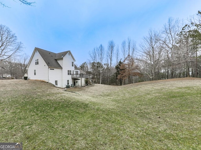 view of side of home featuring a yard and a deck