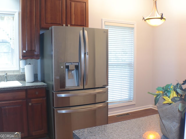 kitchen with pendant lighting, sink, and stainless steel fridge with ice dispenser