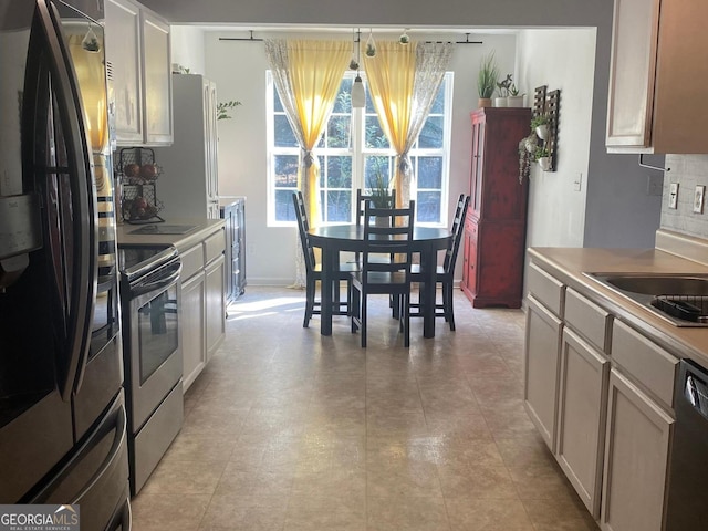 kitchen featuring sink, electric range, fridge, black dishwasher, and backsplash