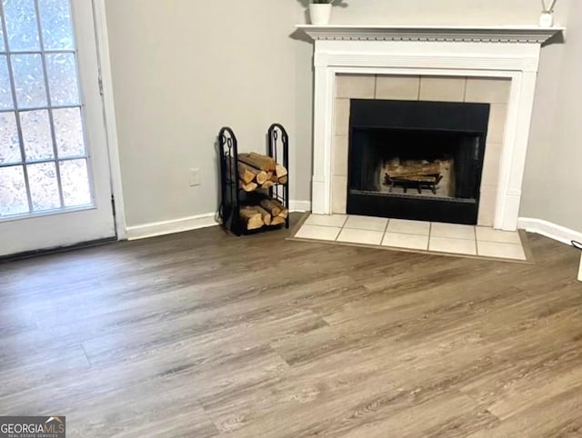 details featuring a fireplace, baseboards, and wood finished floors