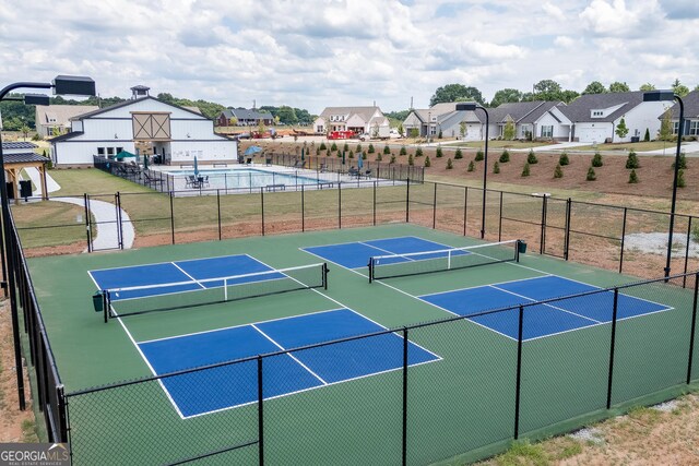 view of tennis court with a lawn