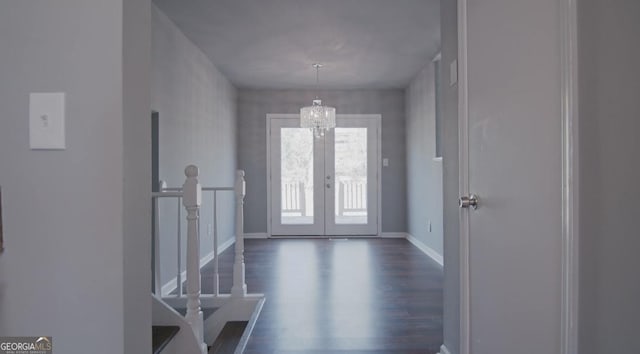 entrance foyer featuring a notable chandelier, dark wood-type flooring, and french doors