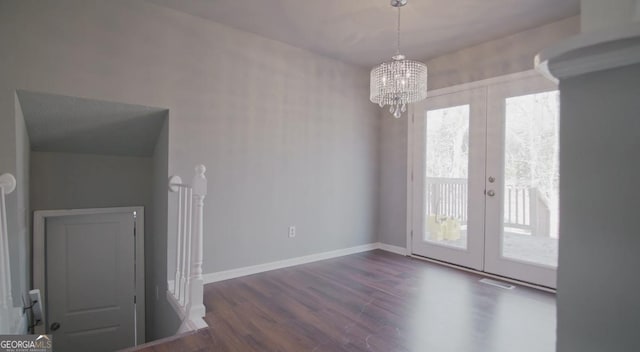 unfurnished dining area with plenty of natural light, dark wood-type flooring, a notable chandelier, and french doors