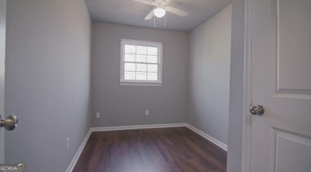 unfurnished room featuring dark wood-type flooring and ceiling fan