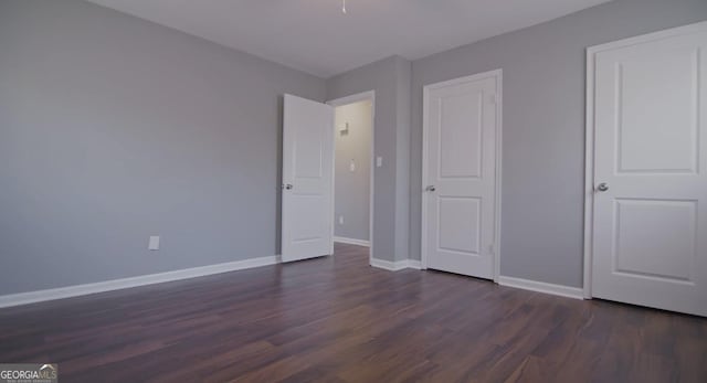 unfurnished bedroom with dark wood-type flooring