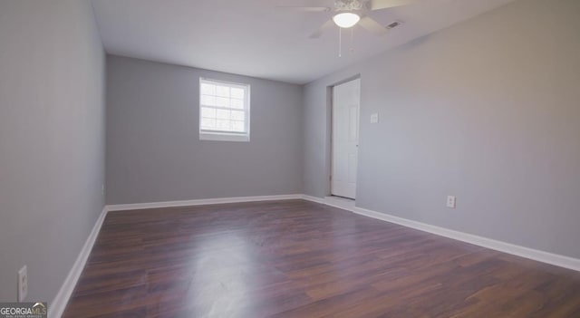 spare room with ceiling fan and dark hardwood / wood-style flooring