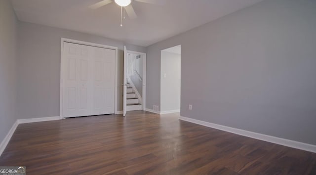 unfurnished bedroom featuring dark hardwood / wood-style floors, a closet, and ceiling fan