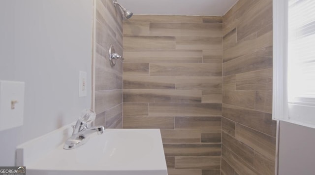 bathroom featuring sink and a tile shower