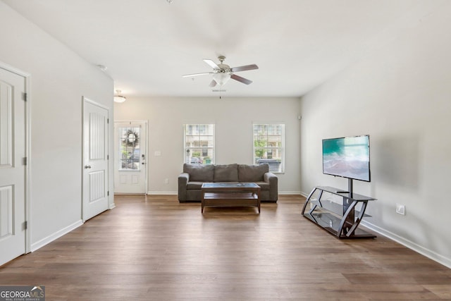 living room with dark wood-type flooring and ceiling fan