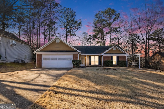 single story home featuring a garage and a lawn