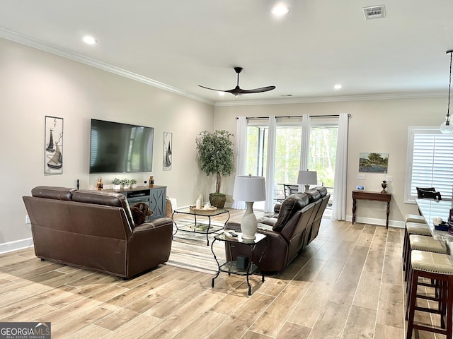 living room with crown molding, light hardwood / wood-style flooring, and ceiling fan