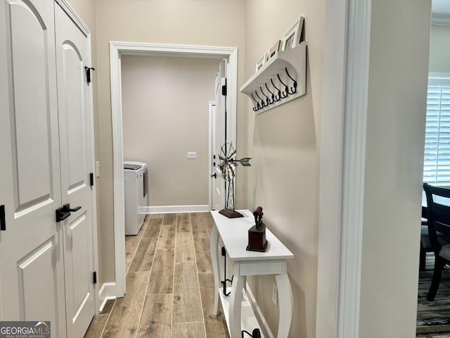 doorway with wood-type flooring and washing machine and dryer