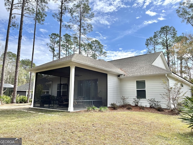 rear view of property featuring a yard, a sunroom, and ceiling fan