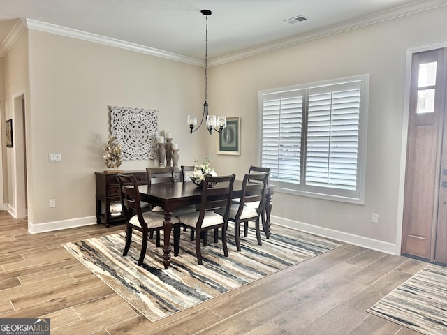 dining room with crown molding and a chandelier