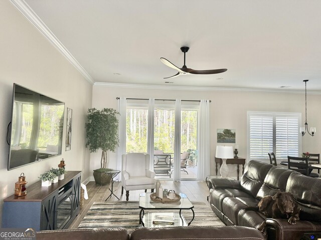 living room with ornamental molding, ceiling fan, and light wood-type flooring