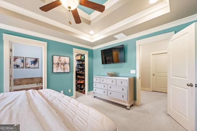 bedroom featuring ceiling fan, connected bathroom, light carpet, a walk in closet, and a closet