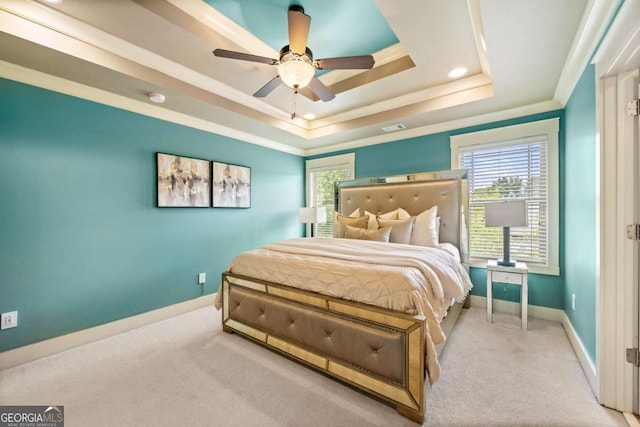 bedroom with light carpet, crown molding, a raised ceiling, and ceiling fan