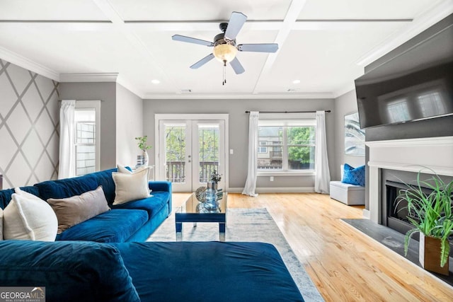 living room with coffered ceiling, crown molding, light hardwood / wood-style flooring, and french doors