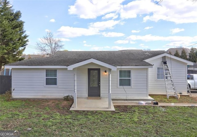 ranch-style house with a front yard and a patio area