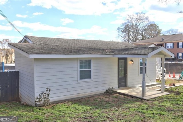 back of property with a yard and a patio