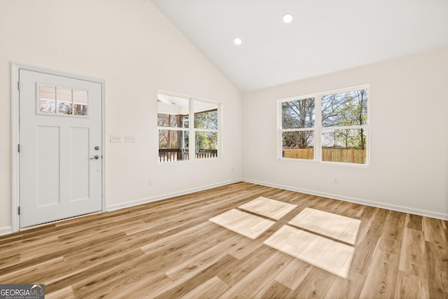 foyer with high vaulted ceiling and light wood-type flooring