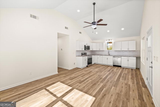 588 S Broad St, Toccoa, GA 30577 - kitchen with appliances with stainless steel finishes, a ceiling fan, high vaulted ceiling, white cabinets, and decorative backsplash