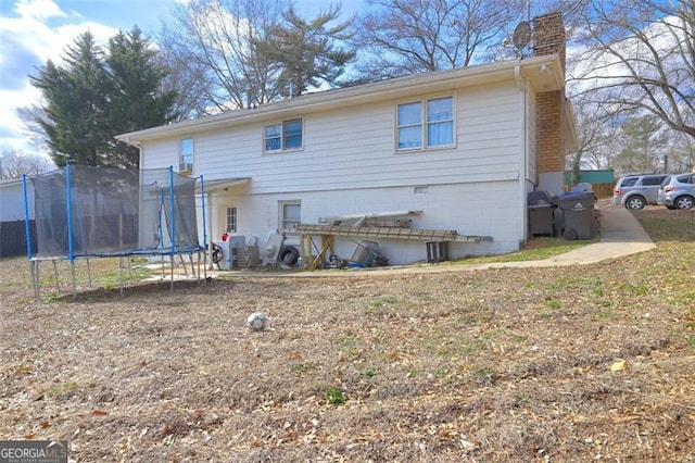 back of property featuring a trampoline