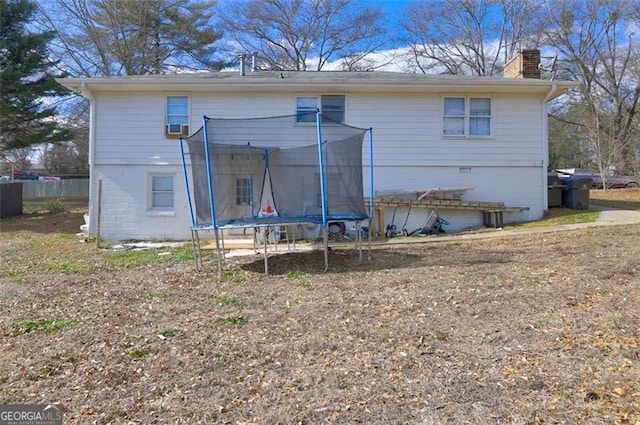 back of property featuring a trampoline and cooling unit