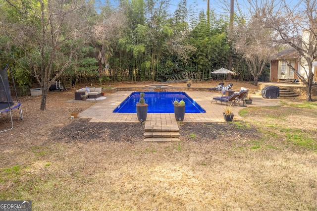 outdoor pool with a trampoline and a patio