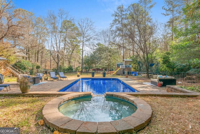 view of swimming pool with a patio, fence, a playground, and an in ground hot tub