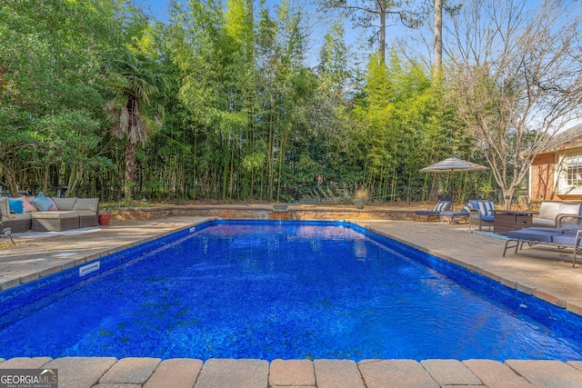 pool featuring a patio, fence, and an outdoor hangout area