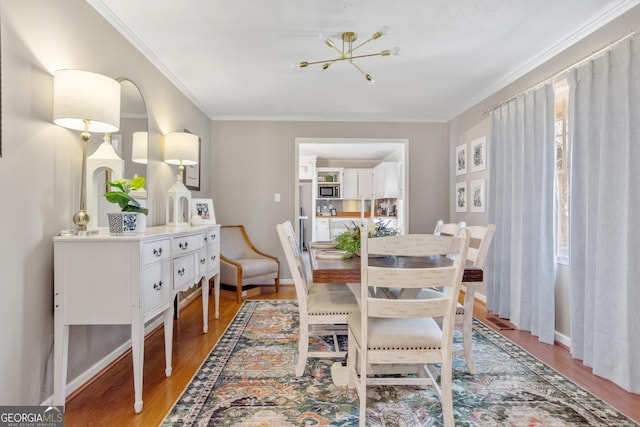 dining area featuring light wood-style flooring, ornamental molding, and baseboards