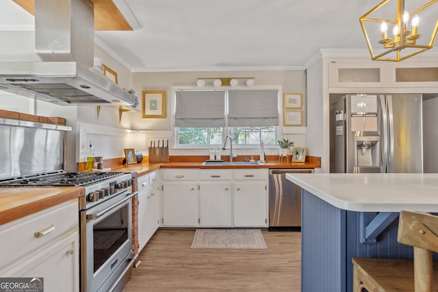 kitchen with island range hood, stainless steel appliances, hanging light fixtures, and white cabinets