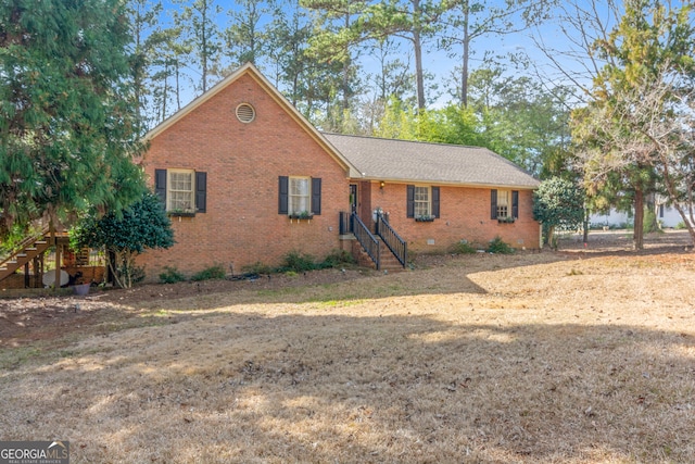 view of front of property featuring crawl space, stairs, a front lawn, and brick siding