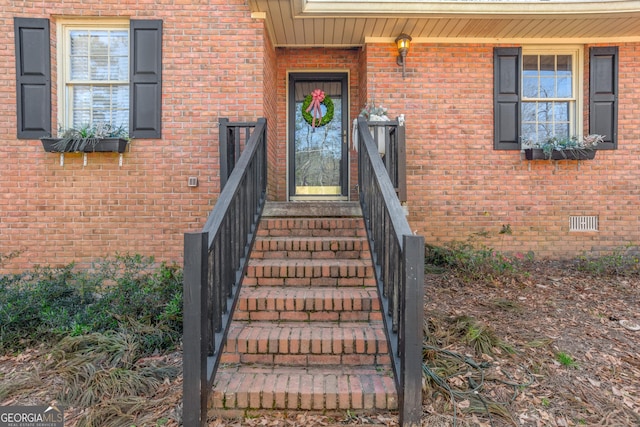 property entrance with brick siding and crawl space