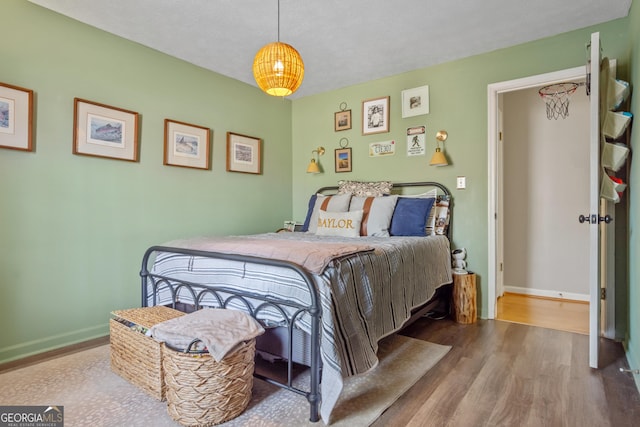 bedroom with baseboards and wood finished floors