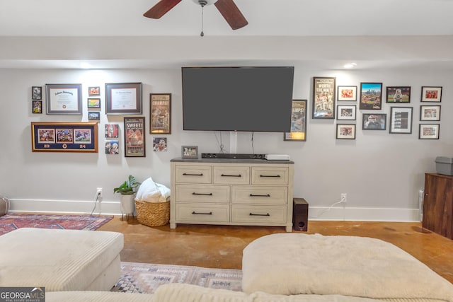 living room with concrete floors, ceiling fan, and baseboards